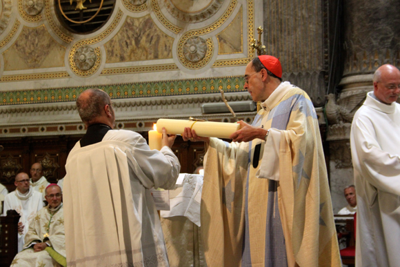 25. Beau symbole, la lourde charge en cire a été conjointement apportée à l'autel par une paroissienne de Vaise et une paroissienne de l'église de Mossoul. 