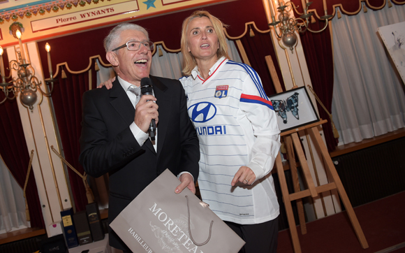 59. Elie Cunat (MBM Association) et le docteur Christine Dubost-Hocquart, portant le maillot de l’OL acquis par Nicolas Gagneux (6ème Sens Immobilier) et offert à Théo